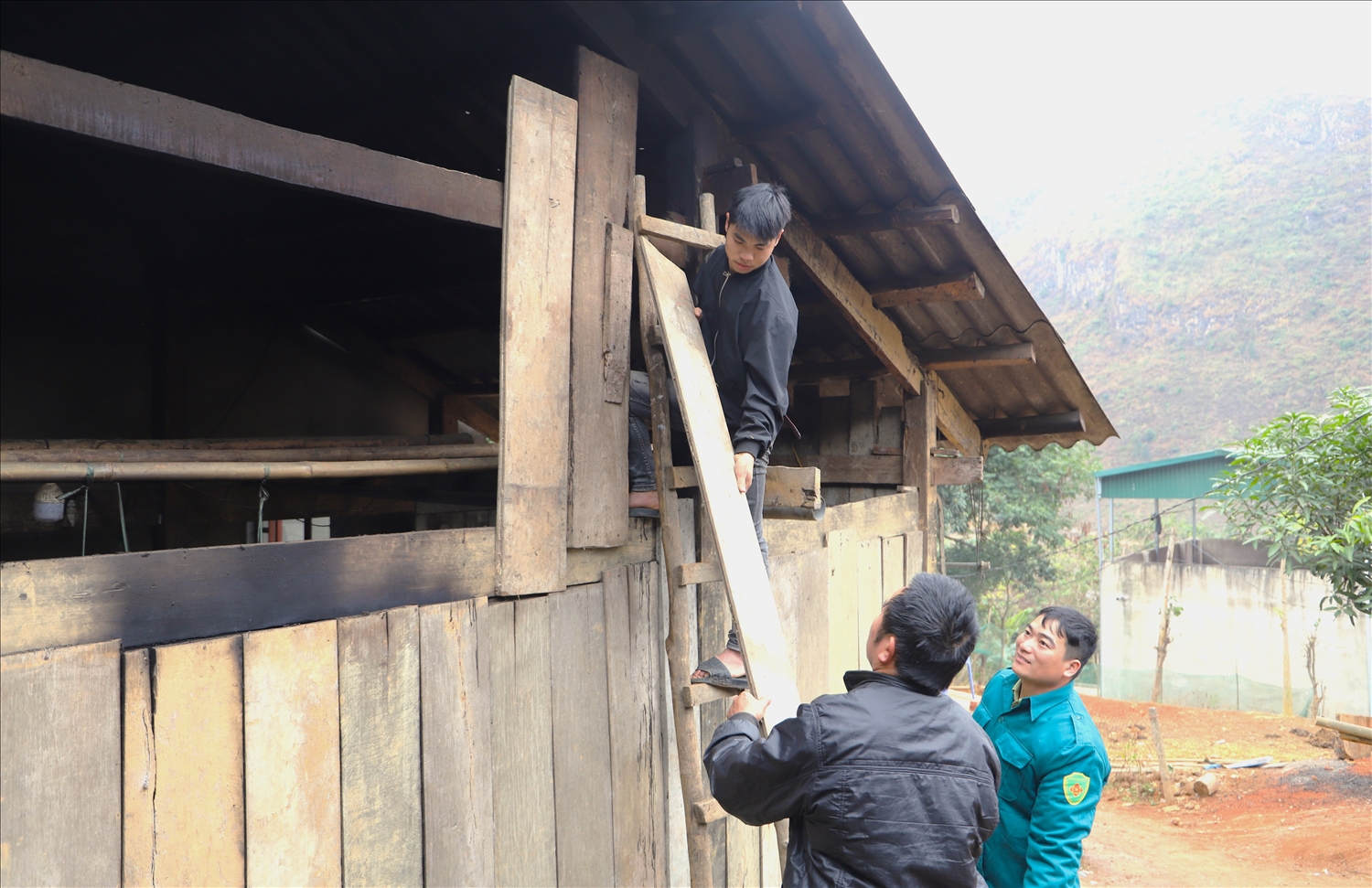 Cán bộ thôn bản hỗ trợ các tân binh sửa chữa nhà cửa trước khi lên đường nhập ngũ