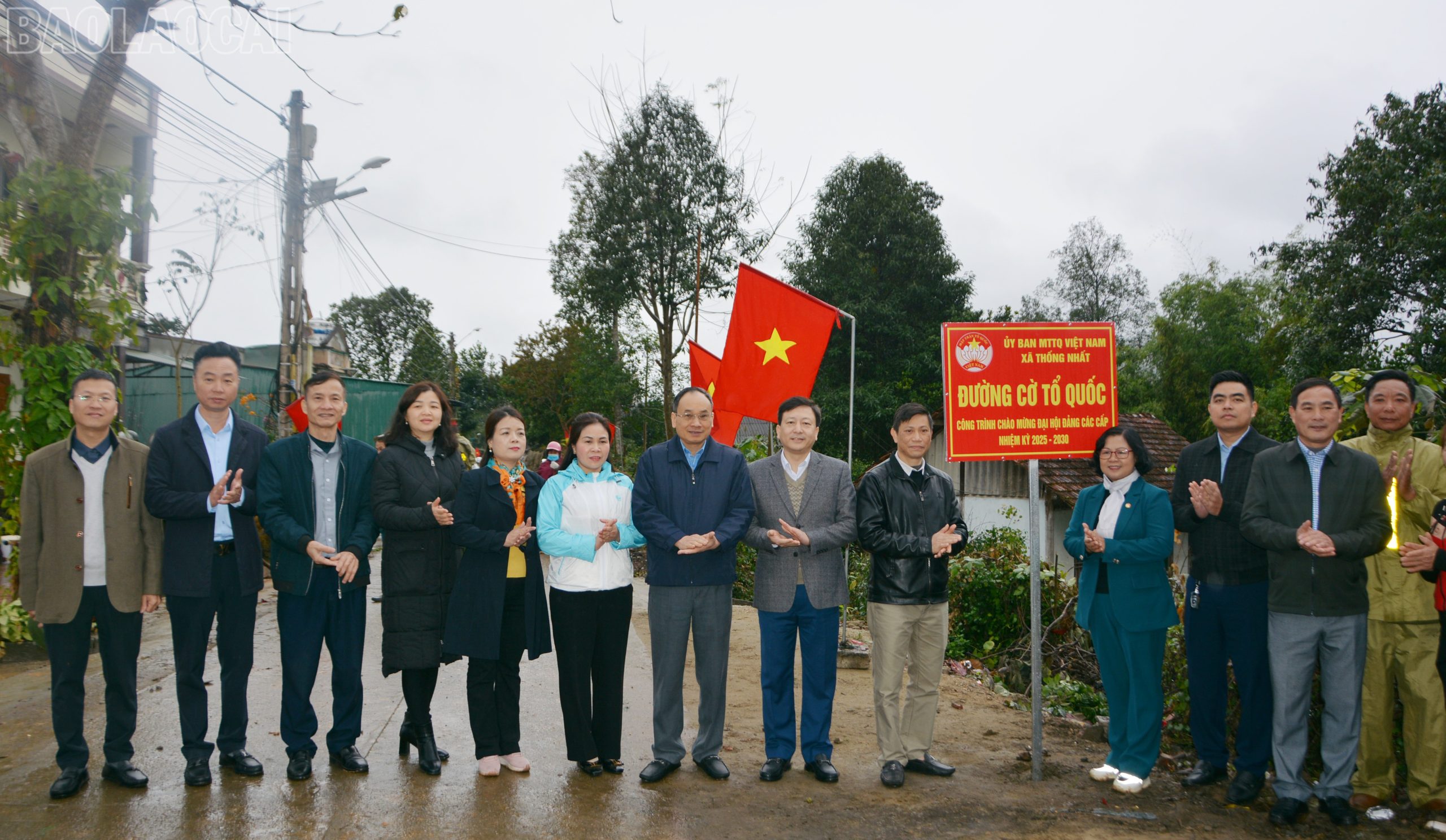 Các đại biểu tham dự chương trình chụp ảnh lưu niệm và tham quan công trình "Đường cờ Tổ quốc" tại thôn Giao Ngay, xã Thống Nhất.(ảnh Báo Lào Cai)