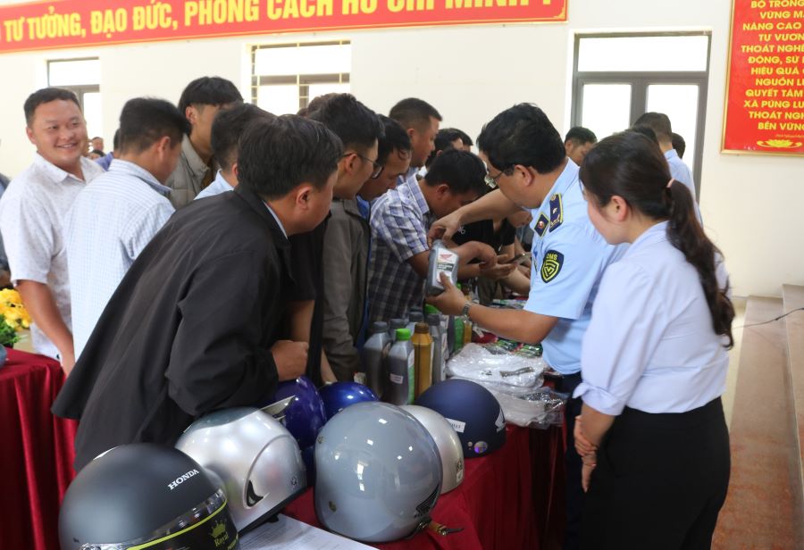 Can bo QLTT tinh huong dan nguoi dan phan biet hang gia
