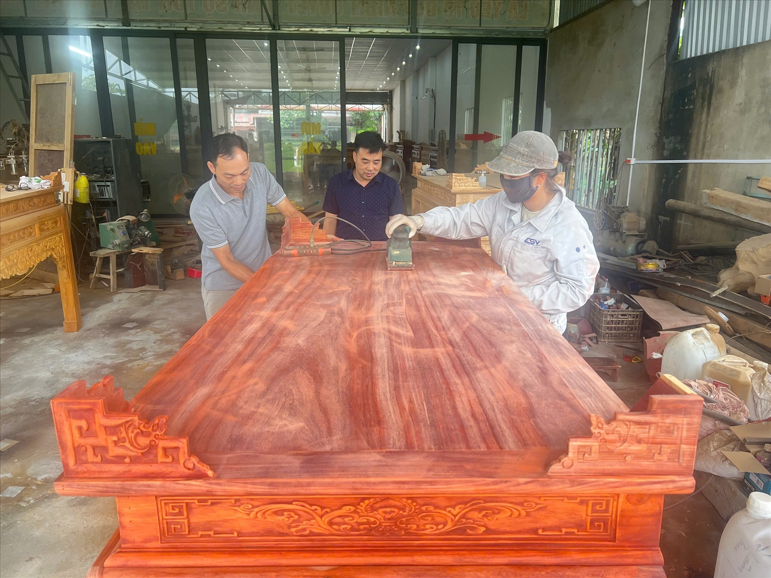 Lào Cai: Sức sống nghề mộc trong đời sống hiện đại 3 Anh Minh Hiếu (bên trái) cùng công nhân đánh bóng cho sản phẩm đồ thờ mỹ nghệ.