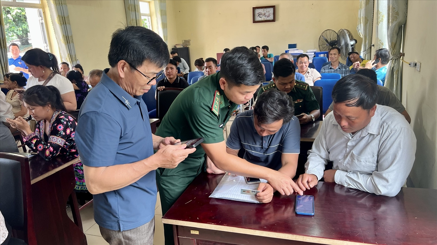 Cán bộ Đồn Biên phòng Pa Tần hướng dẫn cán bộ, công chức xã sử dụng các ứng dụng hỗ trợ giải quyết công việc trên điện thoại