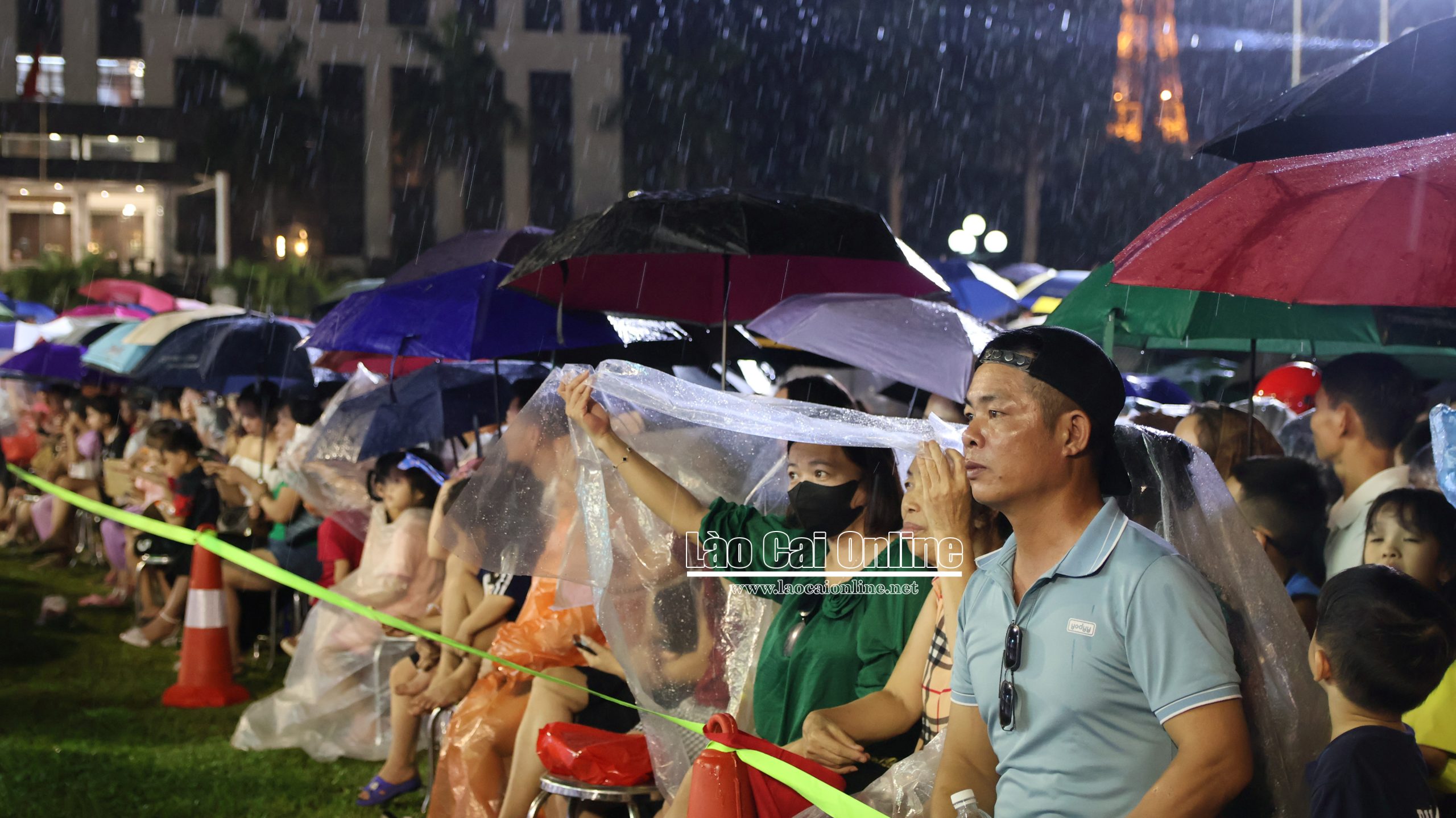 Dù trời mưa to, đông đảo người dân vẫn đội mưa theo dõi và cổ vũ nhiệt tình cho chương trình, tạo nên không khí sôi động và xúc động tại quảng trường. Ảnh : Du Kỷ