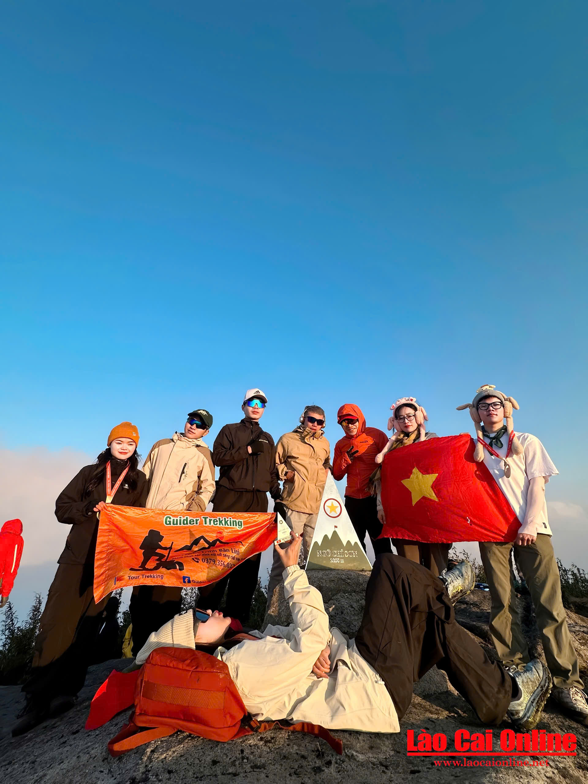 Đoàn trekking của bạn Kim Phương chụp ảnh lưu niệm cùng tấm huy chương và lá cờ Tổ quốc giữa lòng đỉnh núi Ngũ Chỉ Sơn