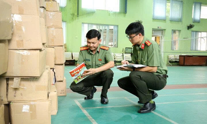 Triệt phá đường dây sản xuất, buôn bán sách giáo khoa giả có quy mô lớn 2 Cán bộ Phòng An ninh chính trị nội bộ (Công an tỉnh Bắc Ninh) kiểm tra tang vật vụ án. (Ảnh: Ngọc Anh)