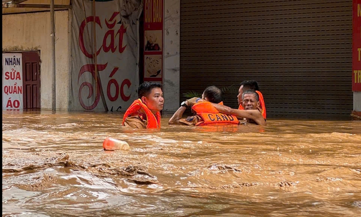 Bộ Công an biểu dương Công an Sơn La cứu dân giữa lũ dữ 3 Công an Sơn La dầm mình trong nước lũ cứu người dân - Ảnh: CAO THIÊN