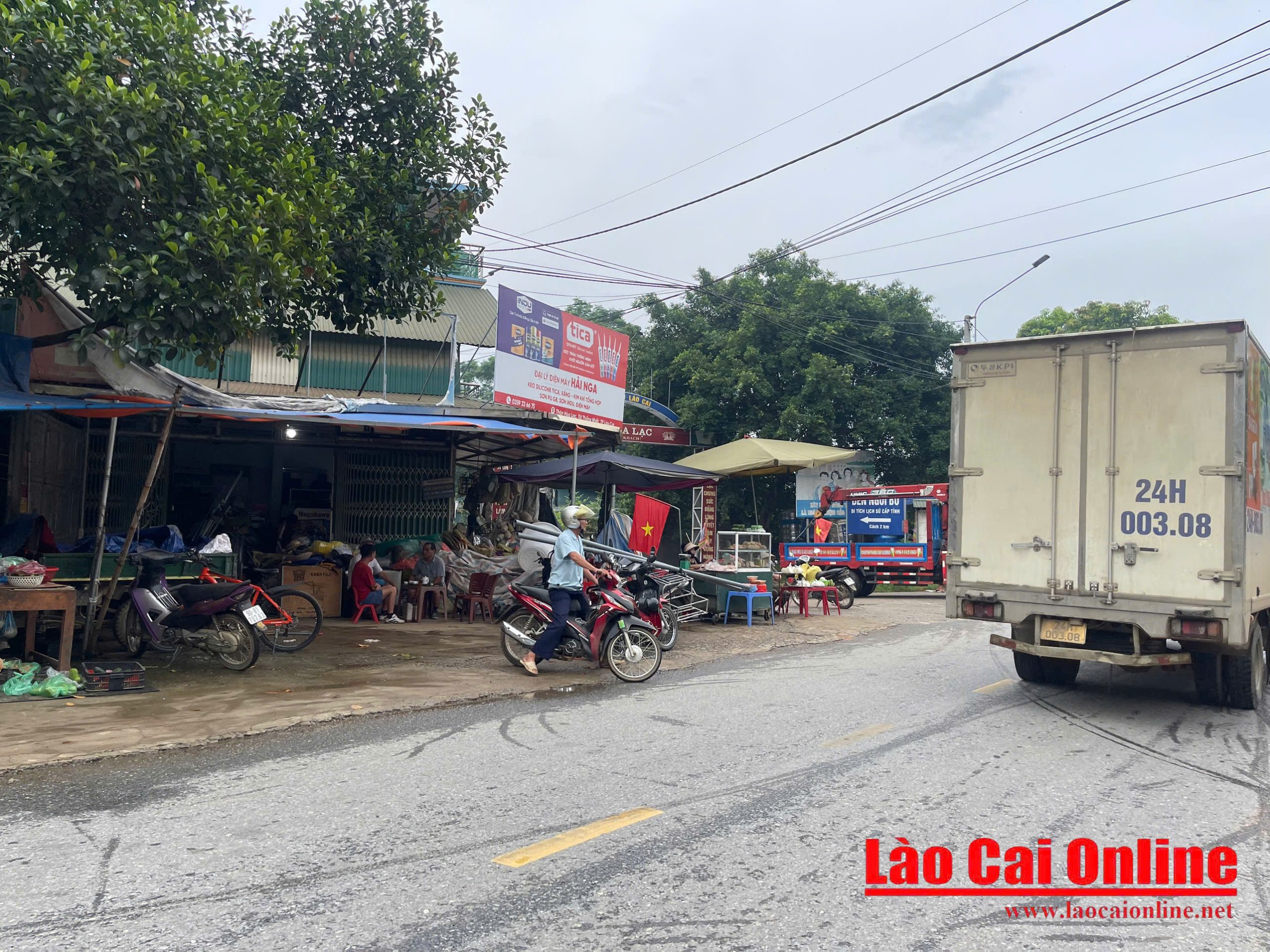 Biển cấm vừa dựng, chợ tự phát ở Gia Phú vẫn nhộn nhịp 4 Nhiều phương tiện lưu thông liên tục qua khu vực biển cấm họp chợ, việc dừng xe mua hàng tại đây tiềm ẩn nguy hiểm . Ảnh Ngọc Anh