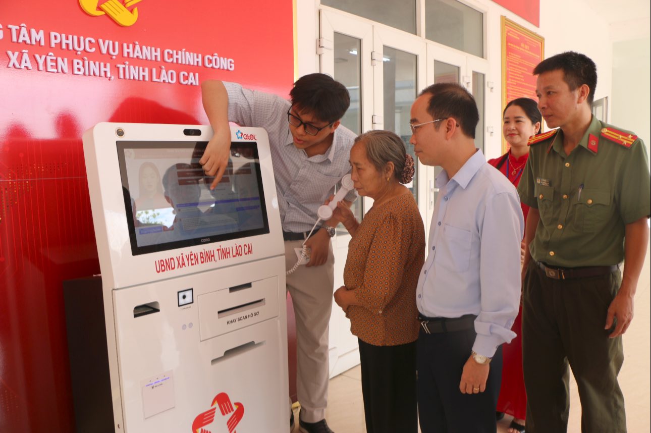 Các đại biểu và người dân tham gia trải nghiệm, thực hành thao tác trên Cabin hành chính công (ảnh tin tức Yên Bình )