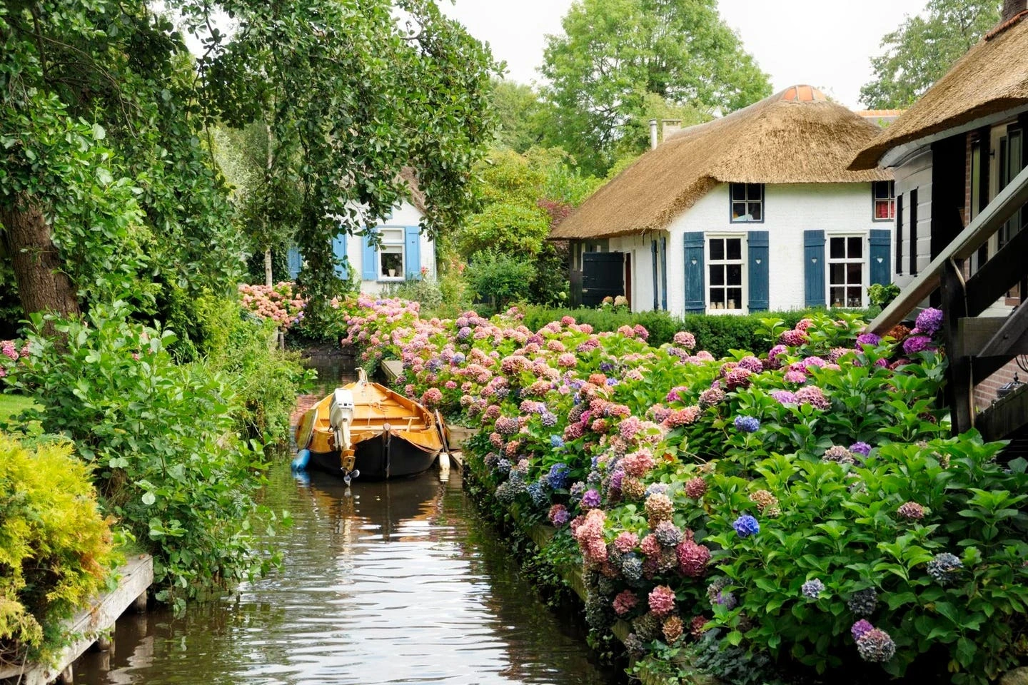 Ẩn mình giữa miền đất thấp Overijssel, Giethoorn hiện lên như viên ngọc sáng giữa những dòng kênh nhỏ. Những ngôi nhà mái tranh soi bóng xuống mặt nước phẳng lặng, được nối liền bằng những cây cầu gỗ cong duyên dáng. Dọc lối đi lát đá cuội, vườn hoa phong lữ đỏ rực xen lẫn oải hương tím biếc tạo nên bức tranh làng quê vừa cổ kính vừa lãng mạn.