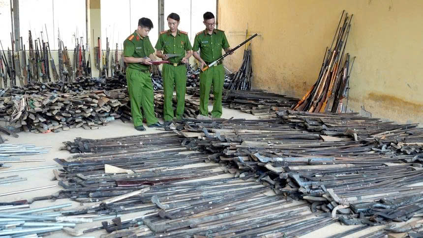 Kiểm đếm các loại vũ khí do người dân giao nộp. (Ảnh Phụ Nữ Việt Nam)