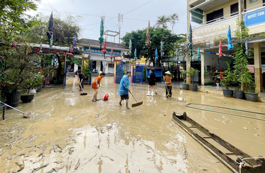 Các thầy cô giáo dọn bùn đất sau lũ tại sân trường Tiểu học Phú Bình, phường Phú Xuân chiều 30/10.