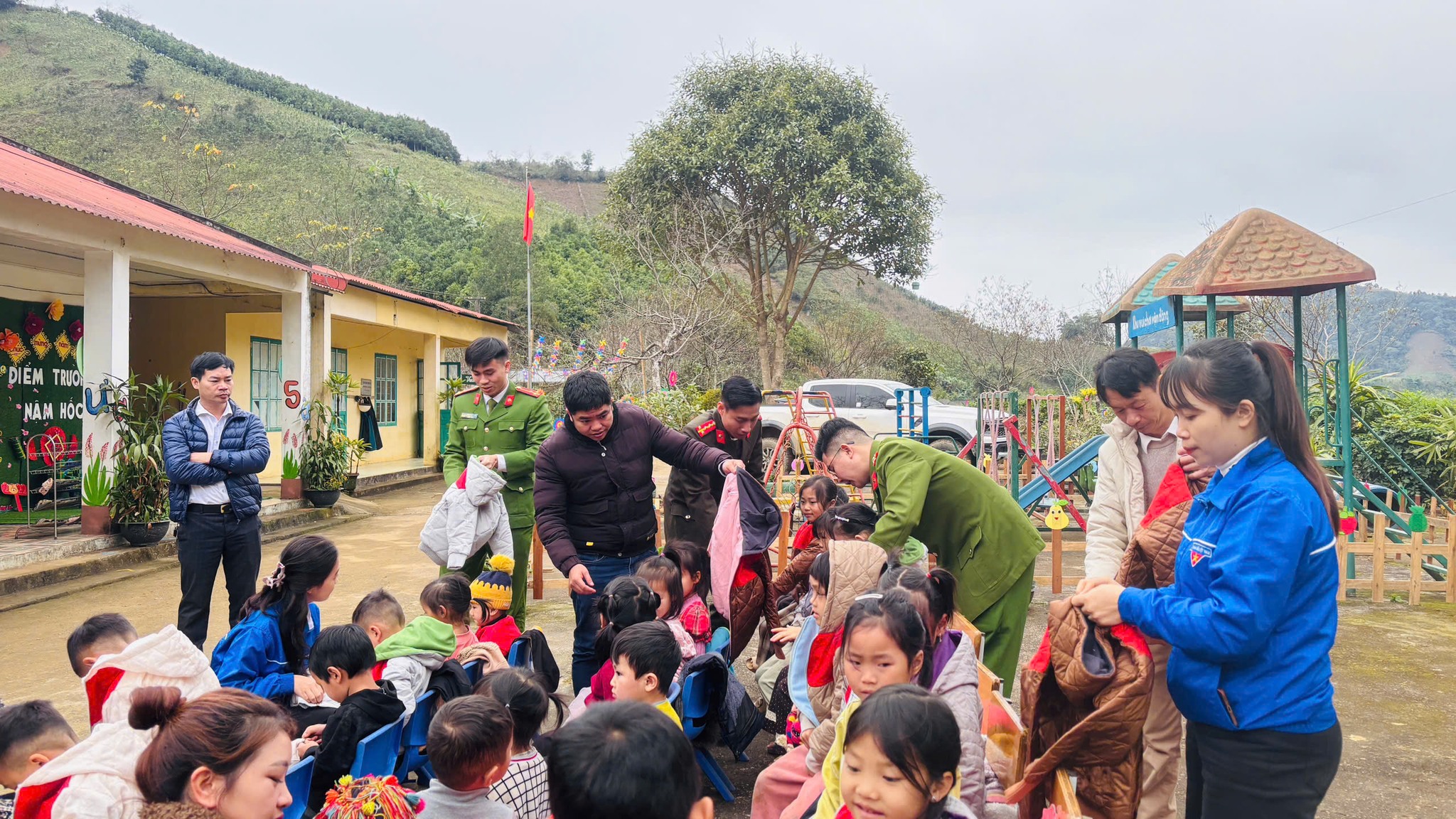 Can bo doan vien truc tiep trao ao am giup cac em mac ao de giu am trong mua dong