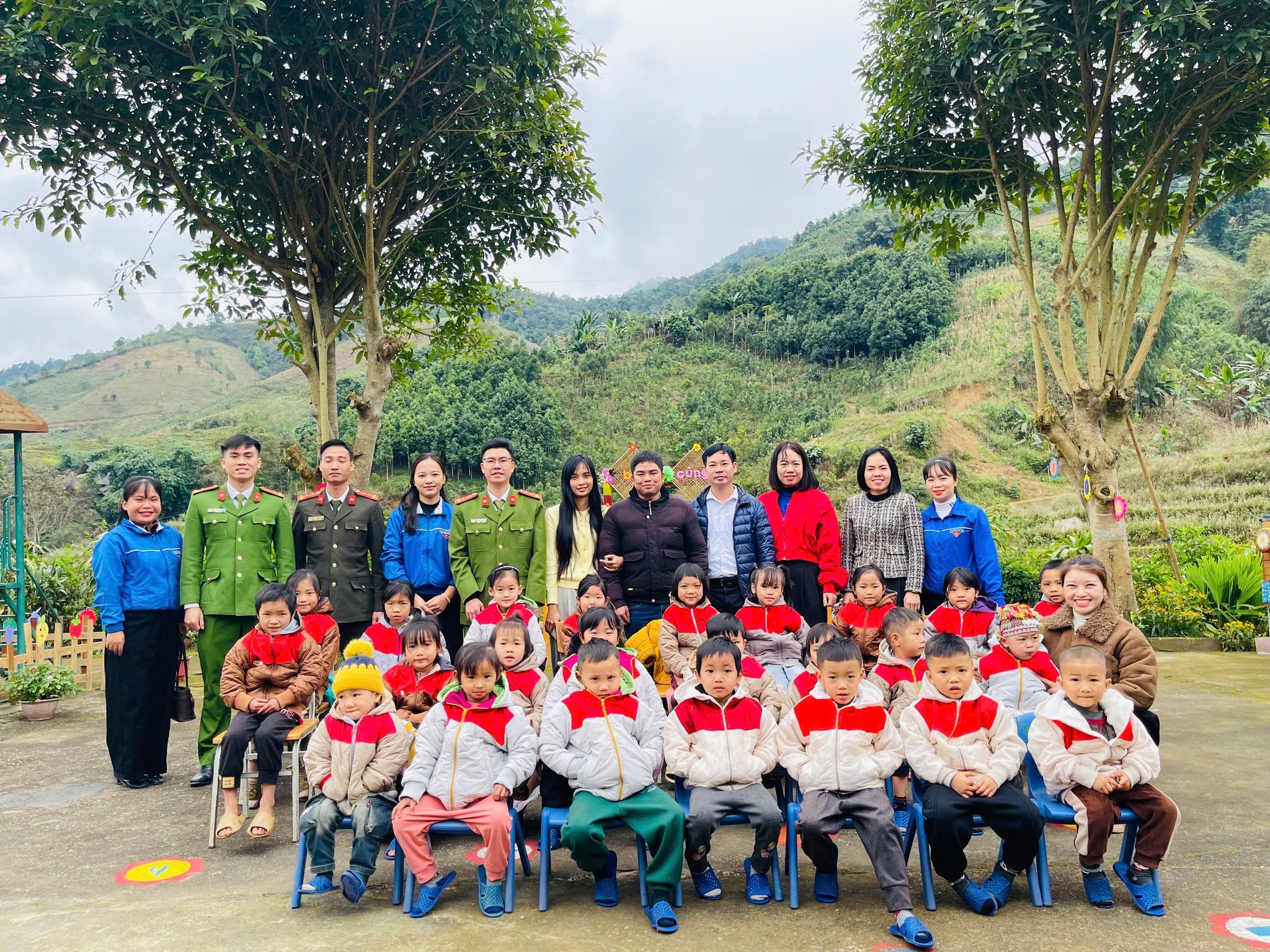 Dai dien Doan Thanh nien Cong an xa nha tai tro va cac thay co chup anh luu niem cung cac em hoc sinh