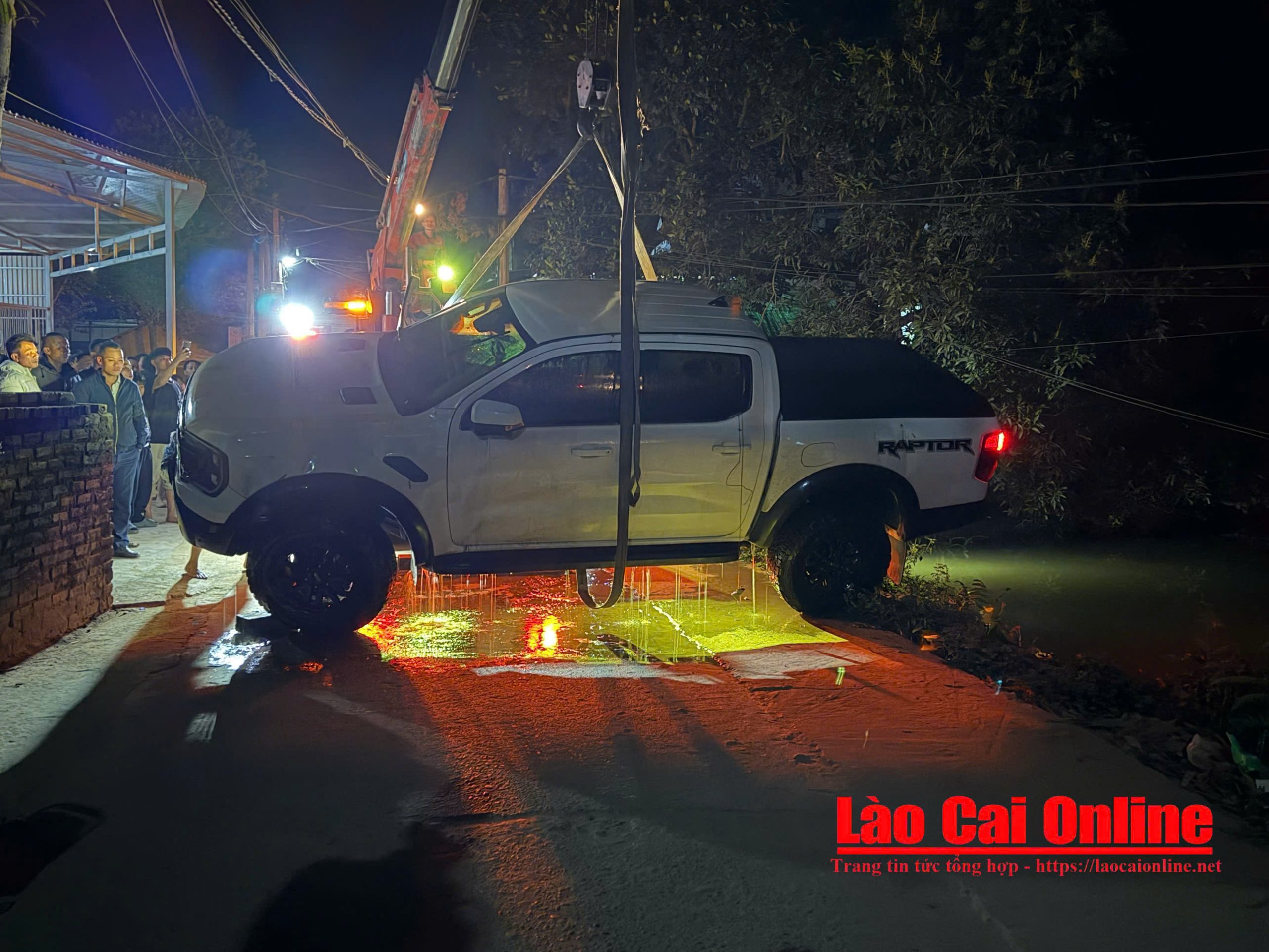 Lực lượng cứu hộ sử dụng xe cẩu trục vớt chiếc xe ô tô bán tải gặp nạn khỏi ao cá trong đêm