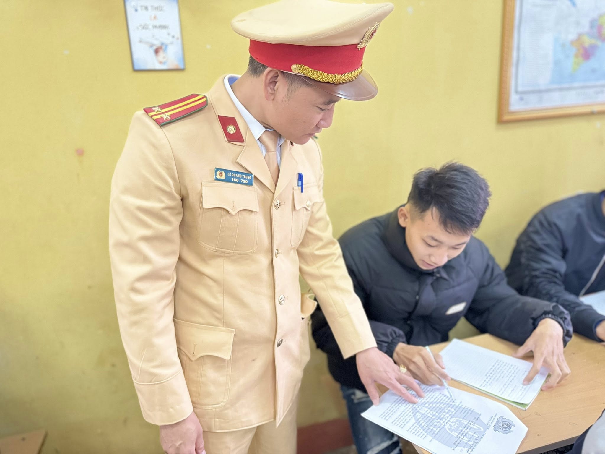 Công an xã Trấn Yên tăng cường giải pháp bảo đảm an toàn giao thông, phòng ngừa tai nạn dịp đầu năm 2 Can bo Canh sat giao thong truc tiep huong dan hoc sinh ghi chep tim hieu cac quy dinh phap luat ve trat tu an toan giao thong