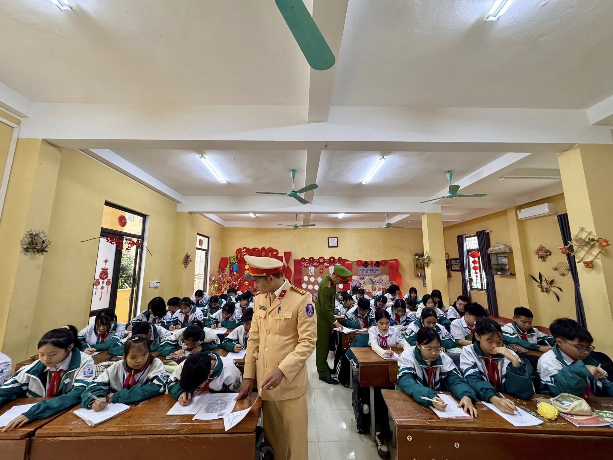 Hoc sinh tap trung viet tay trich dan cac quy dinh cua Luat Trat tu an toan giao thong duong bo theo huong dan cua luc luong Cong an