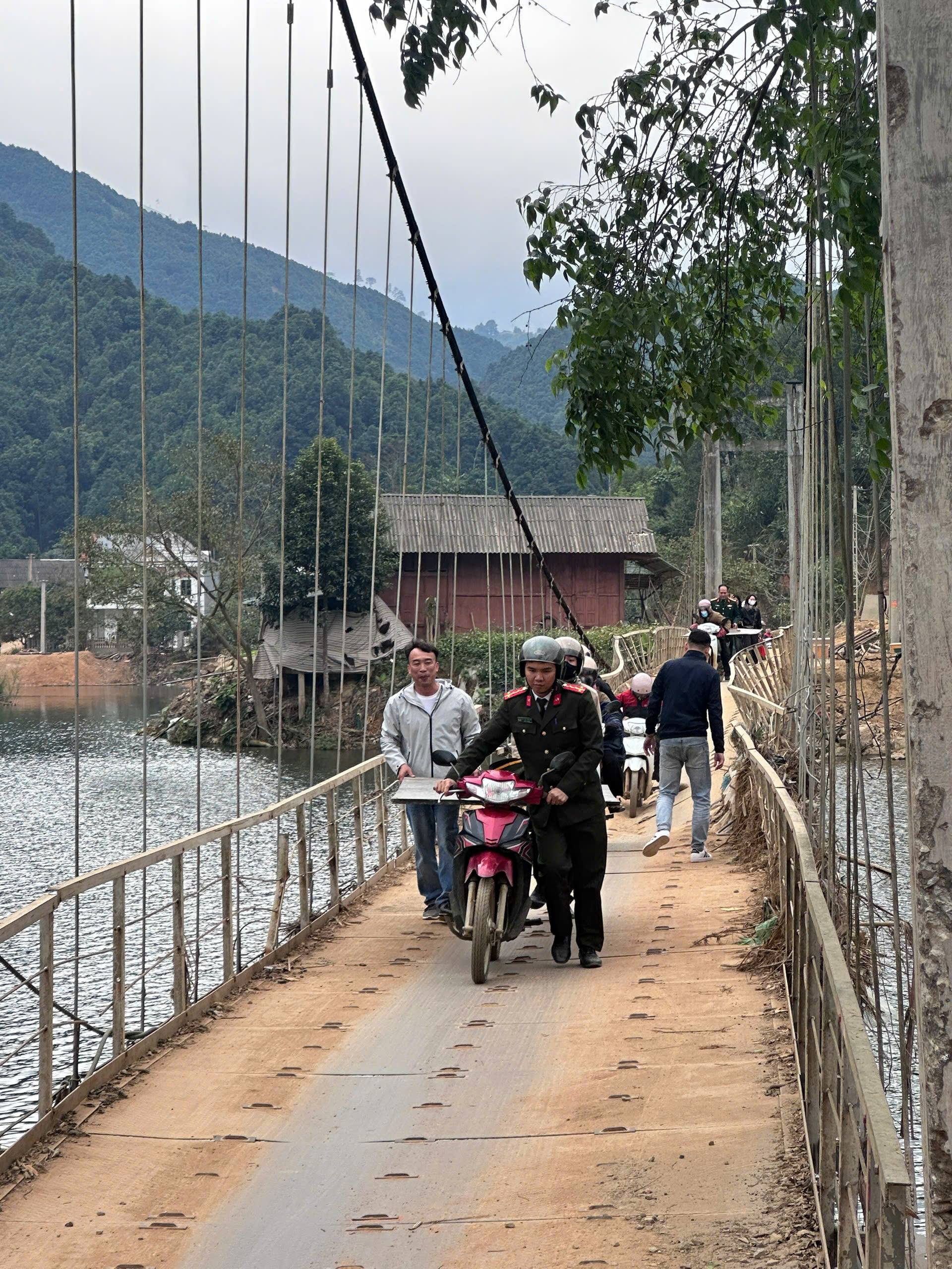 Luc luong Cong an va nguoi dan dia phuong cung vuot cau treo mang vat tu ho tro xay dung diem truong moi