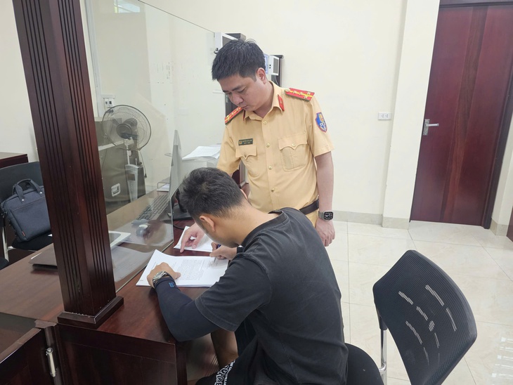 Nam tài xế làm việc với cảnh sát giao thông - Ảnh: Công an cung cấp